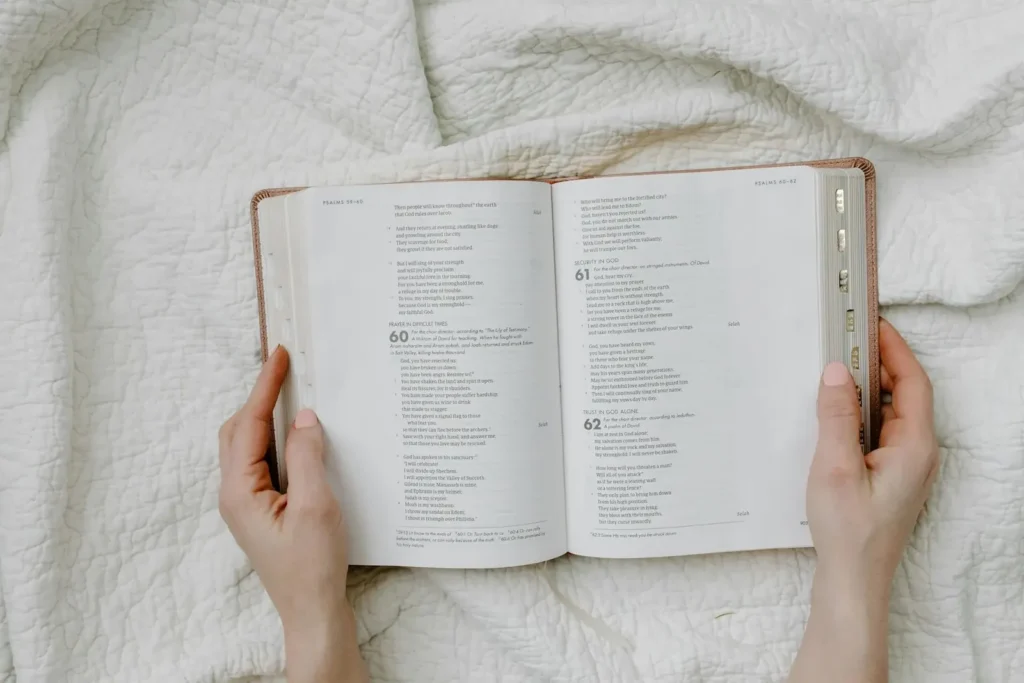 Kobieta trzymająca w dłoniach otwartą Biblię, studiująca fragment z Księgi Psalmów.